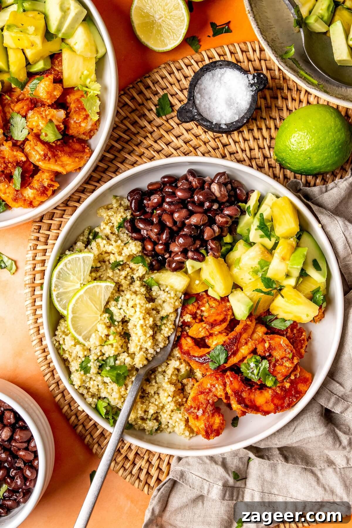 Smoky Shrimp Bowls with Sweet Tropical Salsa 3 Ingredients for Sweet and Smoky Shrimp Bowls laid out on a kitchen counter, showing fresh pineapple, avocado, limes, cilantro, shrimp, and spices.