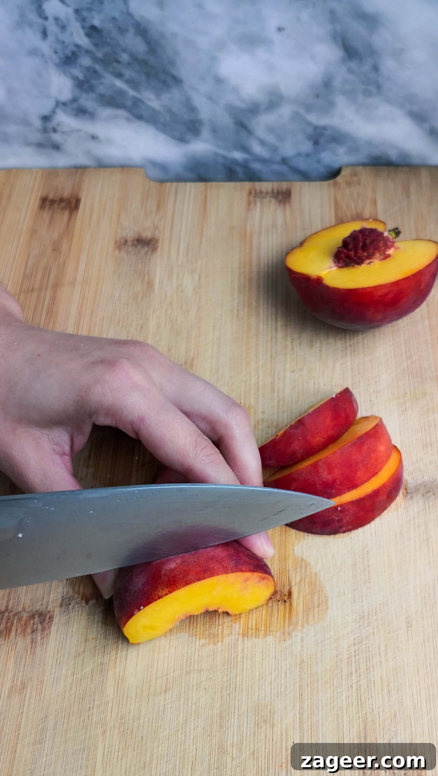 Sweet & Salty Peach Halloumi Salad with Chili Jam 5 Carefully slicing a ripe peach into juicy wedges on a wooden board, ready to be added to the fresh summer salad.