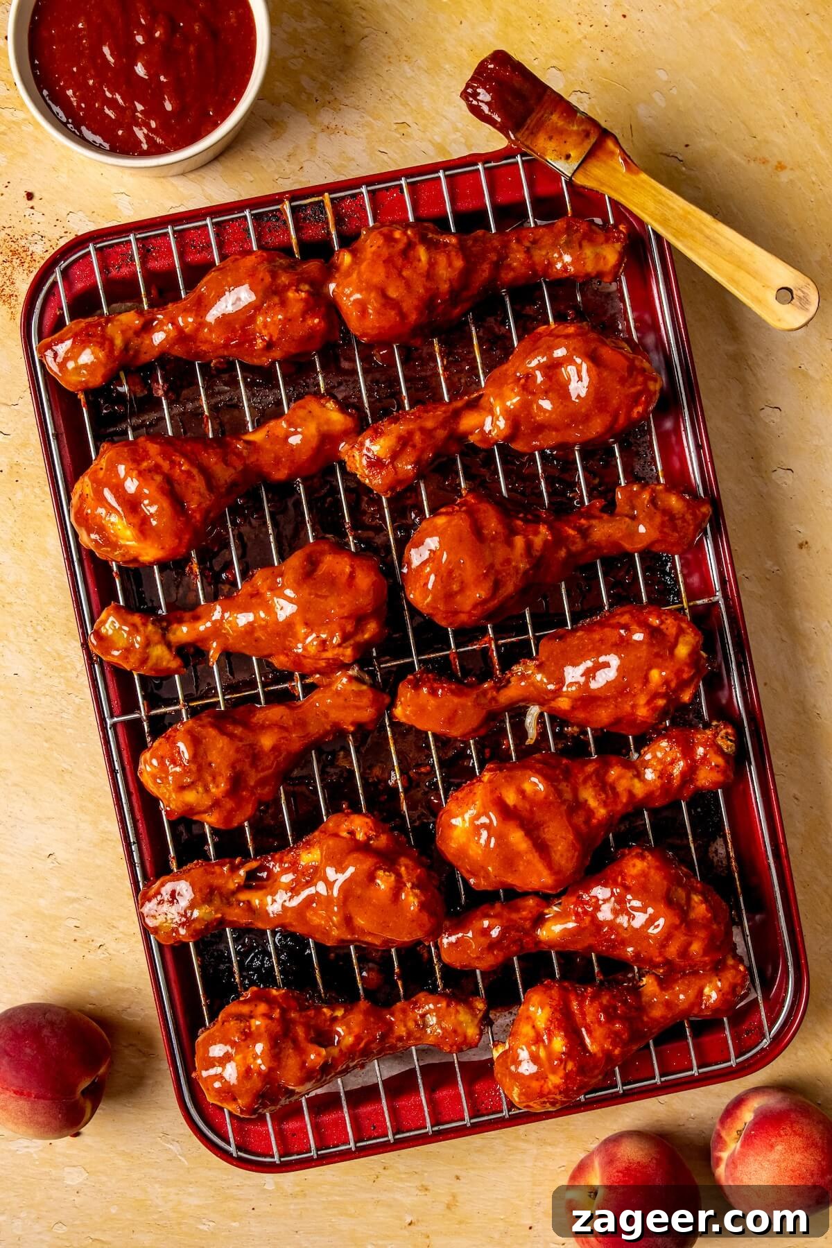 Sweet Peach Glazed Chicken Drumsticks 13 Step 6: Baked chicken drumsticks being basted with peach BBQ sauce - Olivia Adriance