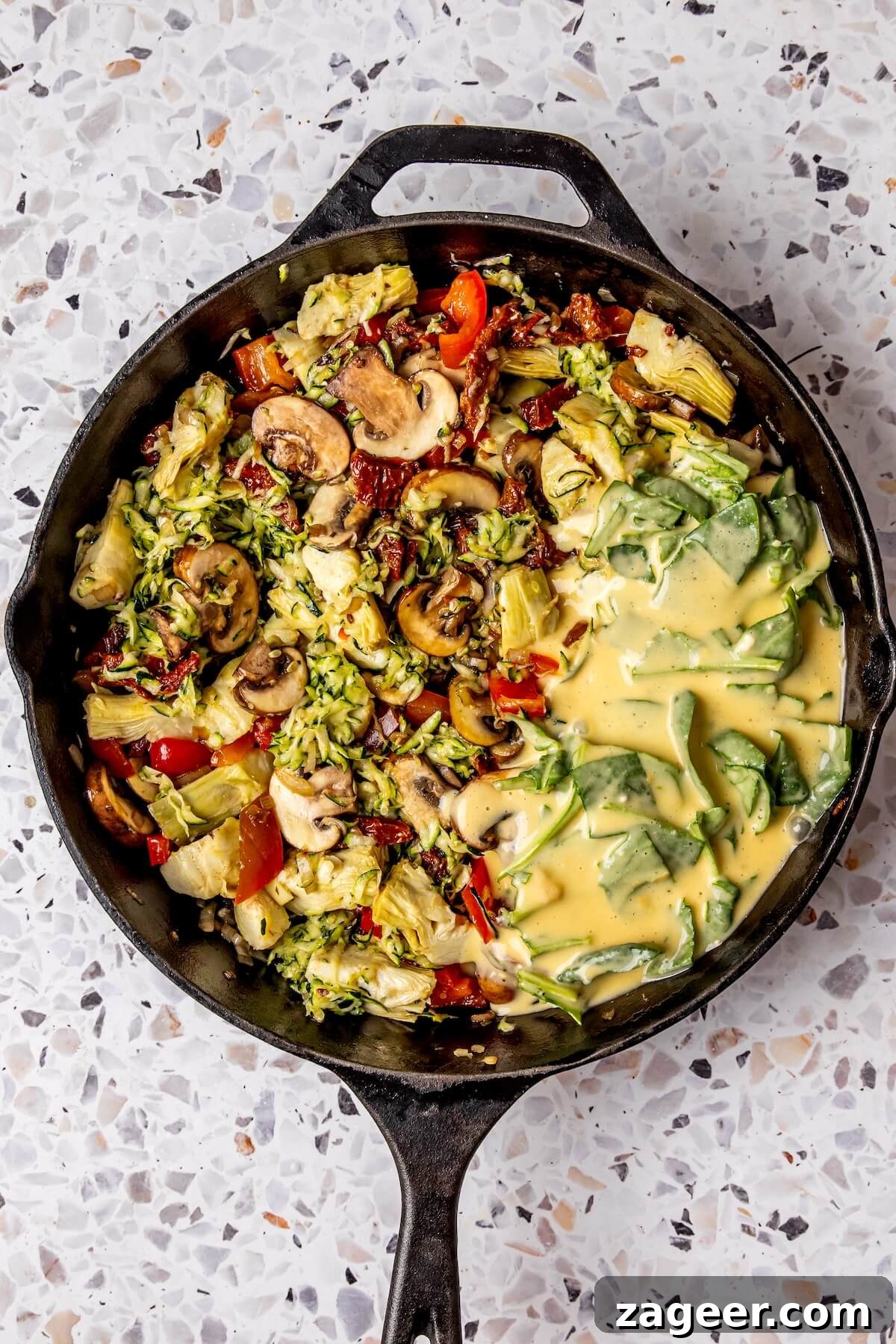Wholesome Spinach, Mushroom, and Artichoke Frittata 12 Egg mixture poured over vegetables in the skillet, ready for baking