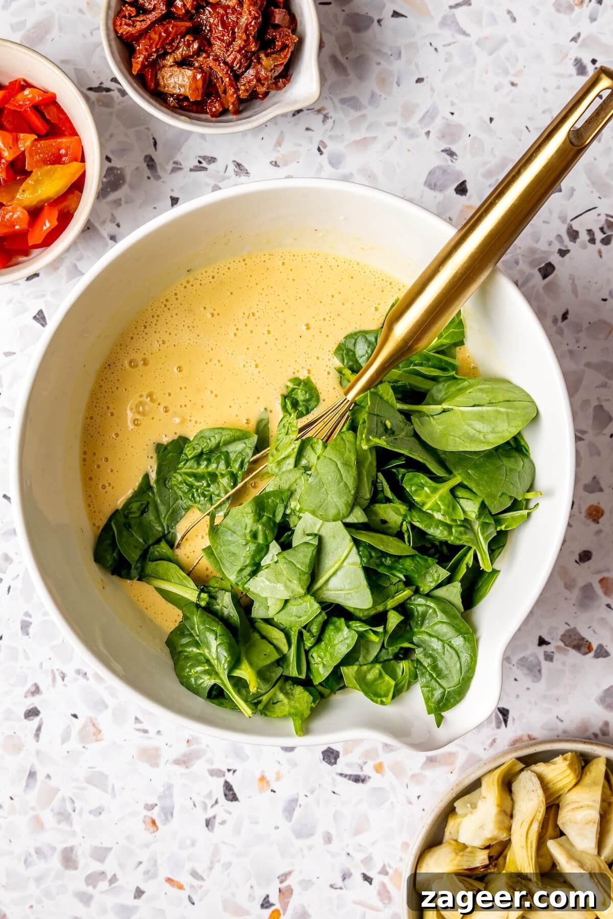Wholesome Spinach, Mushroom, and Artichoke Frittata 10 Whisking eggs and coconut milk in a bowl for the frittata base