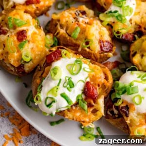 A plate of cheese and bacon potato skins topped with sour cream, melted cheese, crispy bacon pieces, and sliced spring onions.