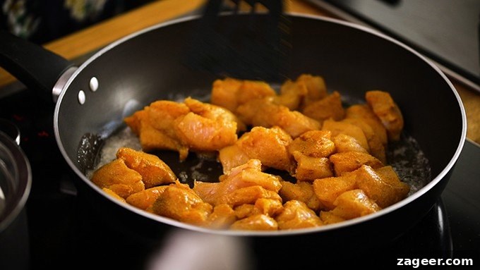Vibrant Spicy Chicken Jalfrezi 4 Close-up of cubed chicken pieces frying in a pan with aromatic Indian spices, creating a delicious aroma.