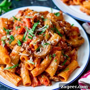 Square image of a plate of mushroom ragu with rigatoni