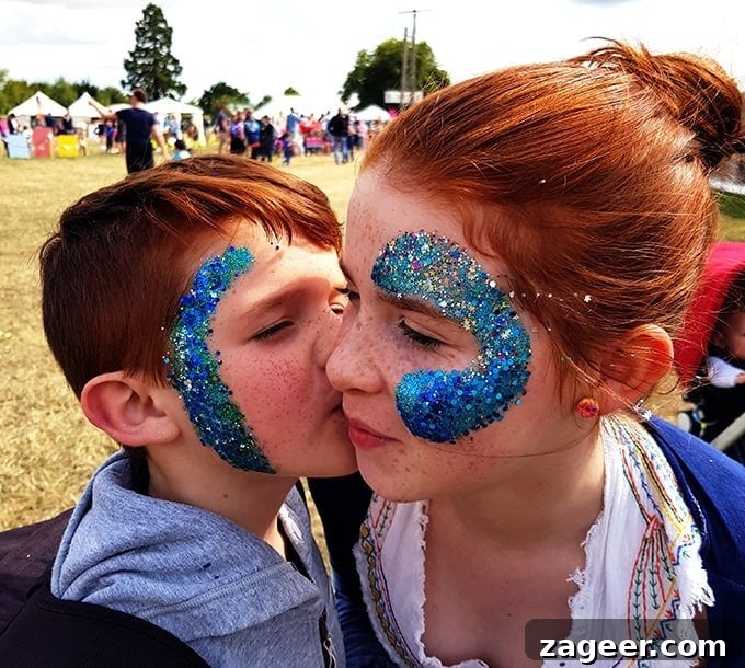 Summer's Fade Brew 9 Two children with sparkling blue glitter painted on their faces, smiling brightly at The Big Feastival