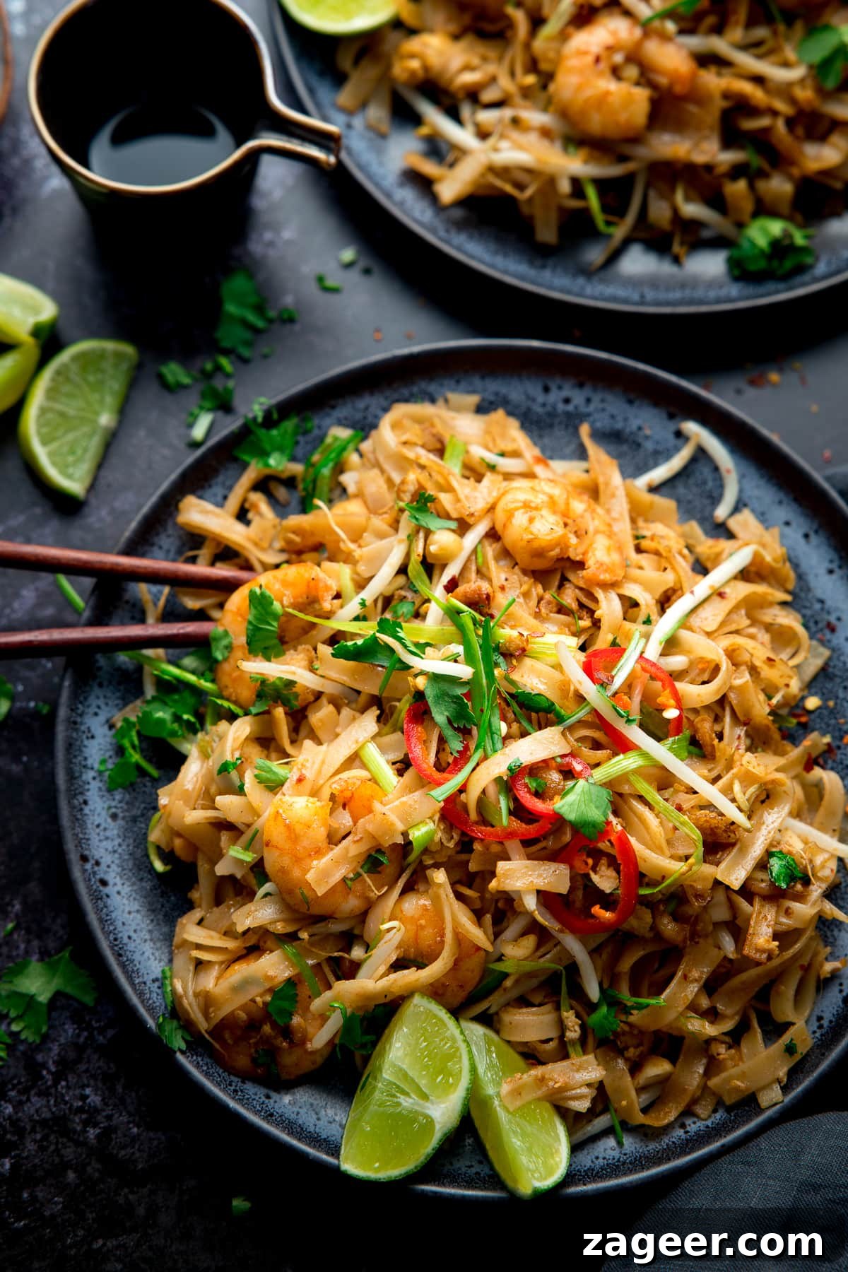 Overhead image of Prawn Pad Thai on a black plate on a black bakcground