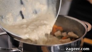 Creamy Chicken Pot Pie Comfort 11 Pouring creamy sauce back into pan with veggies and chicken for pot pie soup