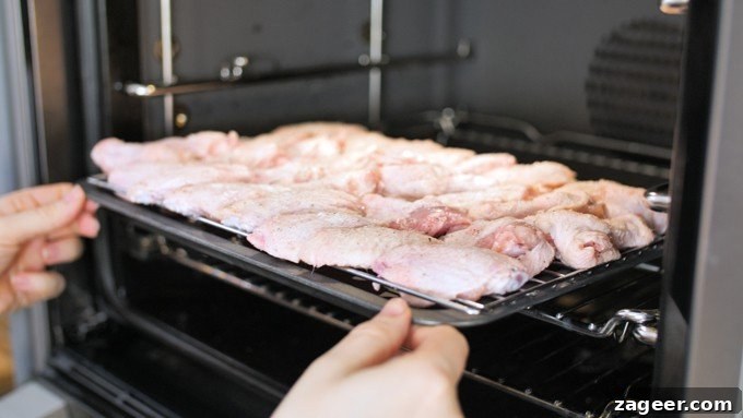 Golden Crisp Oven Buffalo Wings 6 Raw chicken wings on a baking tray, about to go into the oven