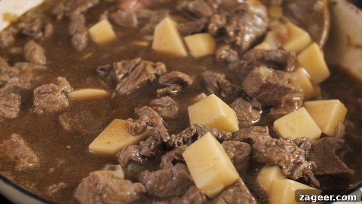 Melt-in-Your-Mouth Slow-Cooked Steak Pie 6 Close-up of the rich, slow-cooked steak and potato pie filling simmering in the pan.