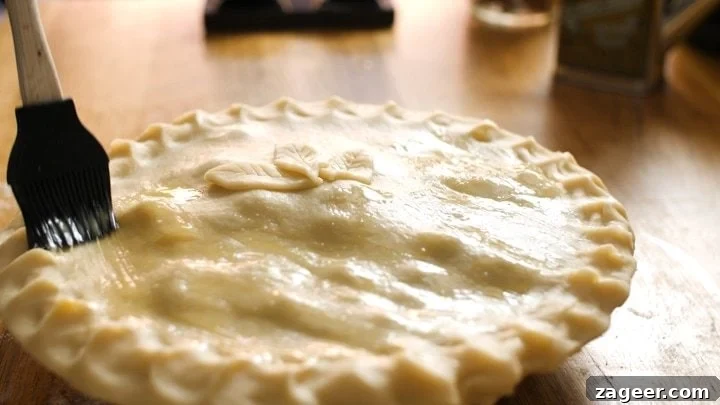 Melt-in-Your-Mouth Slow-Cooked Steak Pie 9 Brushing egg wash over the steak pie before it goes into the oven for a golden finish.