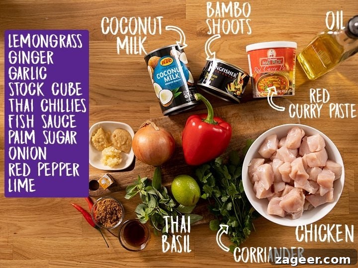 Vibrant Thai Red Chicken Curry 3 A selection of fresh ingredients laid out on a rustic wooden table, including chicken breast, a can of coconut milk, red curry paste, fresh Thai basil, red pepper, and various aromatics, ready for making Thai red chicken curry.