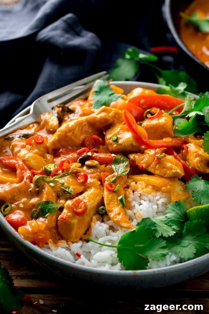 Vibrant Thai Red Chicken Curry 7 A perfectly plated bowl of Thai red chicken curry with white rice, garnished with fresh herbs and a lime wedge, ready to be enjoyed.