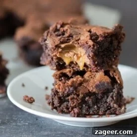 Decadent gooey chocolate caramel brownies, featuring a rich, moist chocolate brownie base with a crisp top and a luscious, gooey caramel center.
