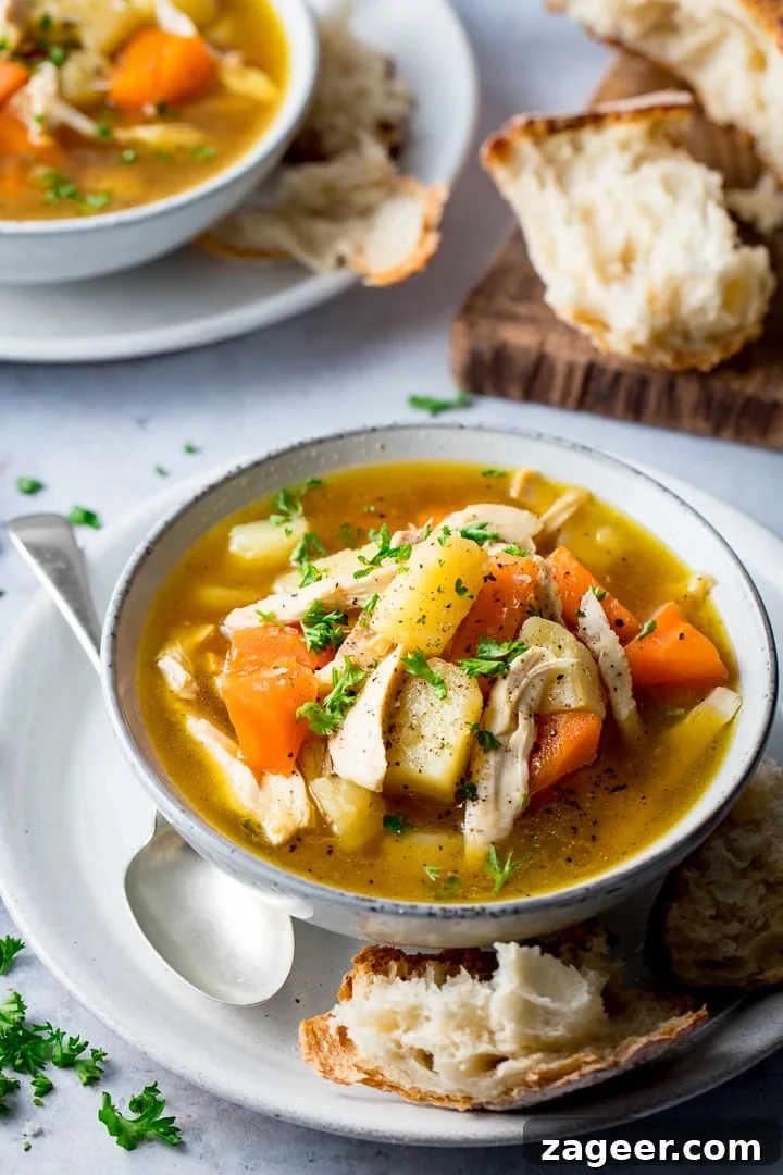Hearty Loaded Chicken Vegetable Soup 2 A steaming bowl of homemade chicken and vegetable soup with crusty bread on the side, ready to be enjoyed.