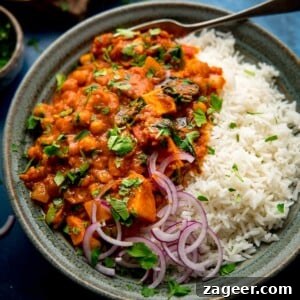 chickpea and sweet potato curry in a bowl with rice and red onion