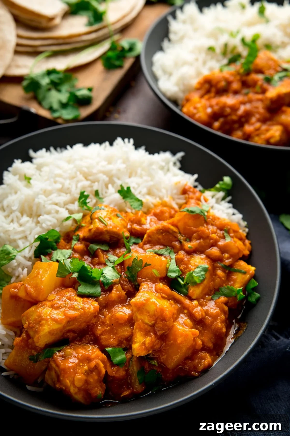 Aromatic Lentil Chicken Curry 5 A dark bowl filled with chicken dhansak and basmati rice