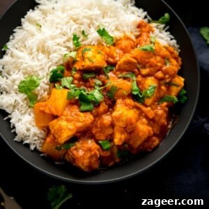 Chicken Dhansak with rice in a black bowl, ready to serve