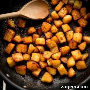 Garlic Sautéed Potatoes 7 Square image of saute potatoes in a pan with a wooden spoon
