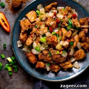 salt and pepper chicken on a dark blue plate