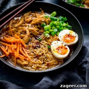Chicken Ramen in a black bowl topped with egg, carrots and spring onions