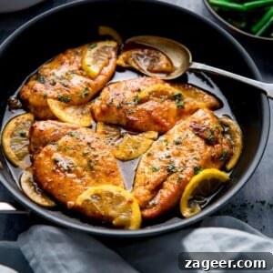 Square image of a dark pan filled with honey lemon chicken.