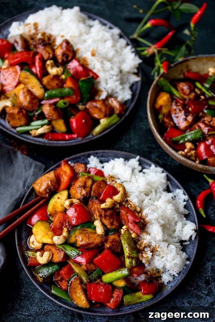 Szechuan Chili Peanut Chicken 9 Two plates of delicious homemade Kung Pao Chicken served with fluffy white rice, ready to eat.