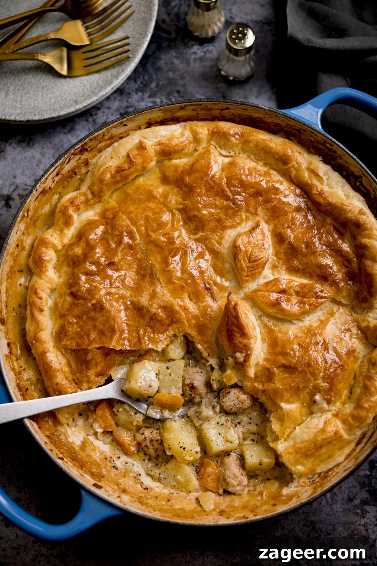 Artisan Sausage and Mustard Bake 4 Overhead image of a spoonful being taken from the filling of a pastry-topped sausage and mustard pie.