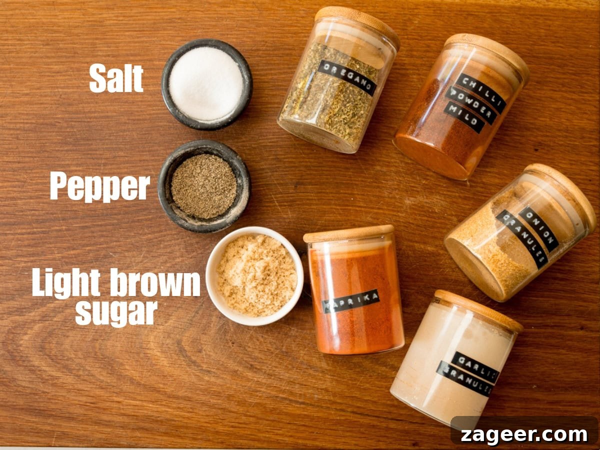 Smoky Dry Rub BBQ Ribs 3 The ingredients for the BBQ Dry Rub Ribs seasoning are neatly arranged on a wooden cutting board. Labels in white text accompany some items, while others are in jars with black labels and white text. These include Salt, Pepper, Light Brown Sugar, Oregano, Paprika, Mild Chilli Powder, Onion Granules, and Garlic Granules, highlighting the simple yet potent blend.