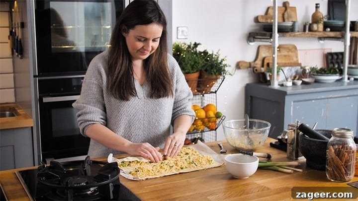 The Secret to Vegetarian Sausage Rolls That Meat Eaters Crave 8 Hands carefully rolling up puff pastry around the cheesy filling to form a vegetarian sausage roll.