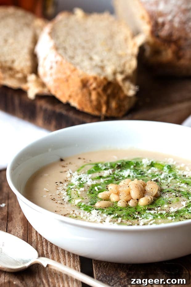White Bean Soup with Zesty Pesto and Rich Parmesan 4 Serving of vegetarian white bean soup with parmesan and pesto, garnished with fresh basil