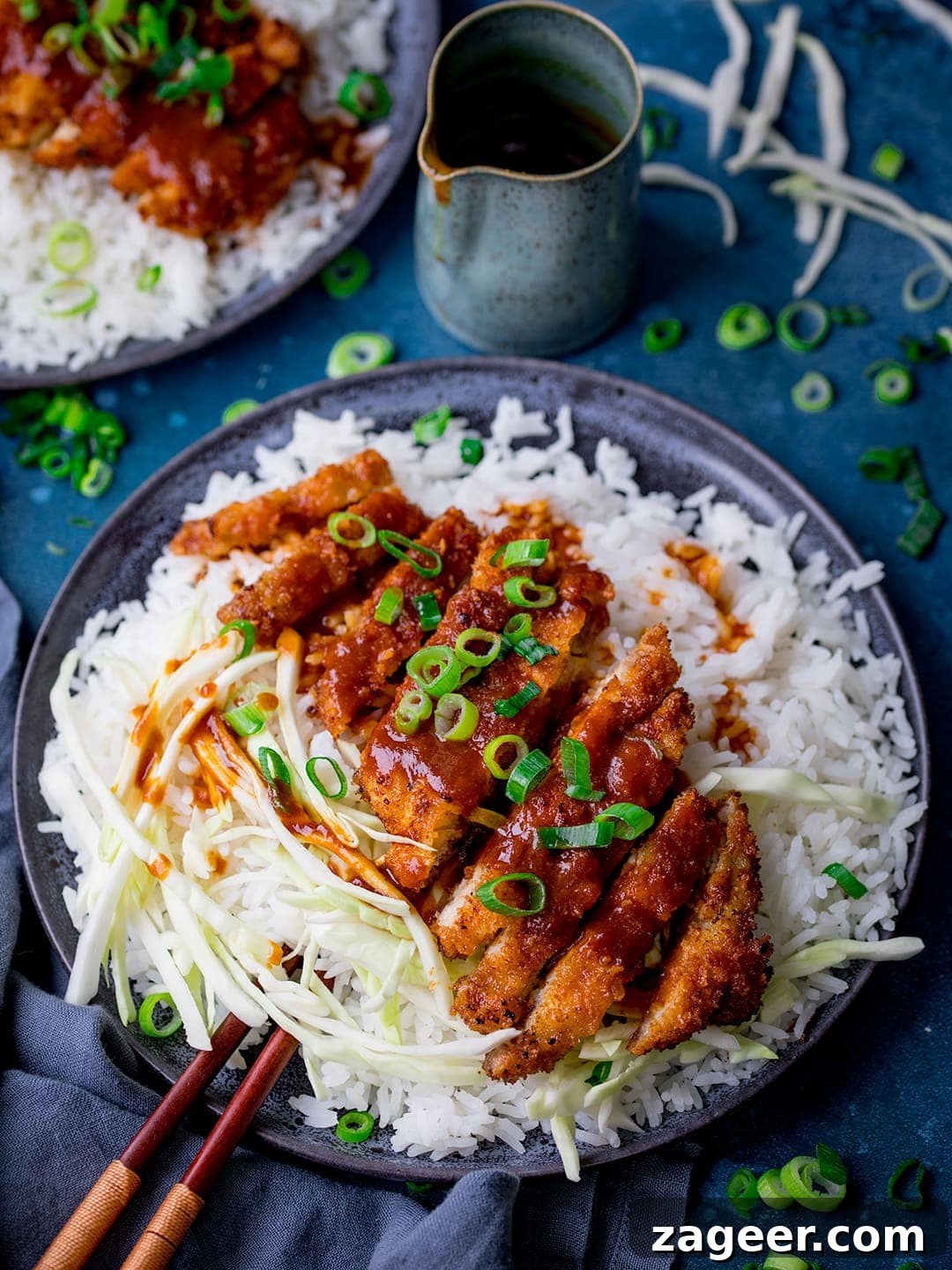 Fiery Crispy Tonkatsu 2 Tonkatsu pork curry on a dark plate with rice and cabbage