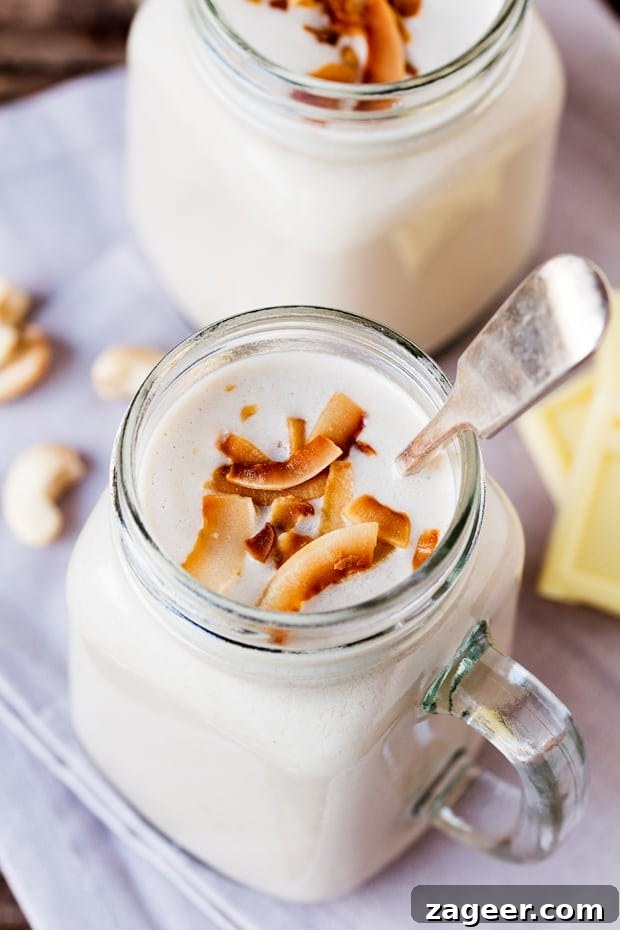 Creamy Hot White Chocolate Coconut Cashew Smoothie 5 Close up overhead shot of a White Chocolate Coconut Cashew Hot Smoothie with toasted coconut flakes