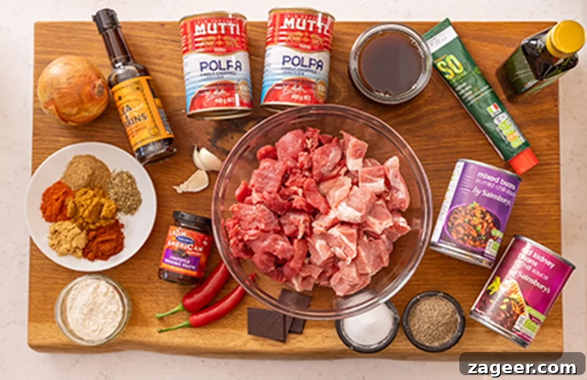 Hearty Slow Cooker Pork and Beef Chili 3 Ingredients for slow cooker pork and beef chilli on a wooden board.