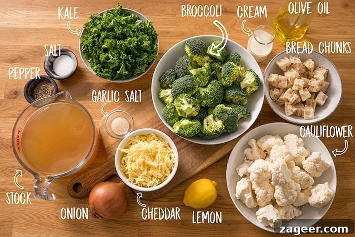 Velvety Broccoli Cream 3 Ingredients for broccoli soup on a wooden table, including fresh broccoli, cauliflower, kale, grated cheddar cheese, a whole onion, and a measuring jug of stock
