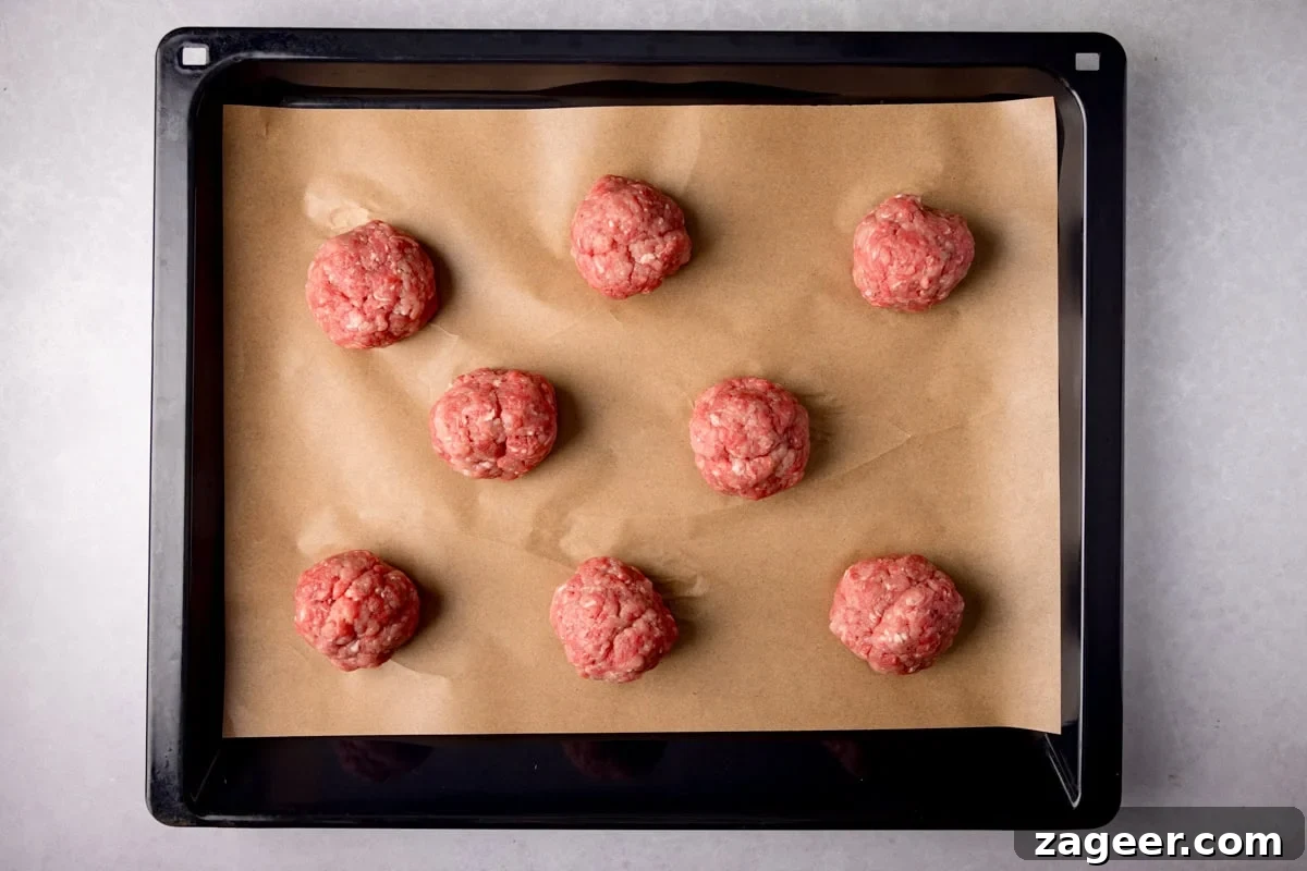 Meal Prep Powerhouse: Homemade High Protein Sausage and Egg McMuffin 4 Raw sausage patty mixture divided into equal balls, ready for pressing.
