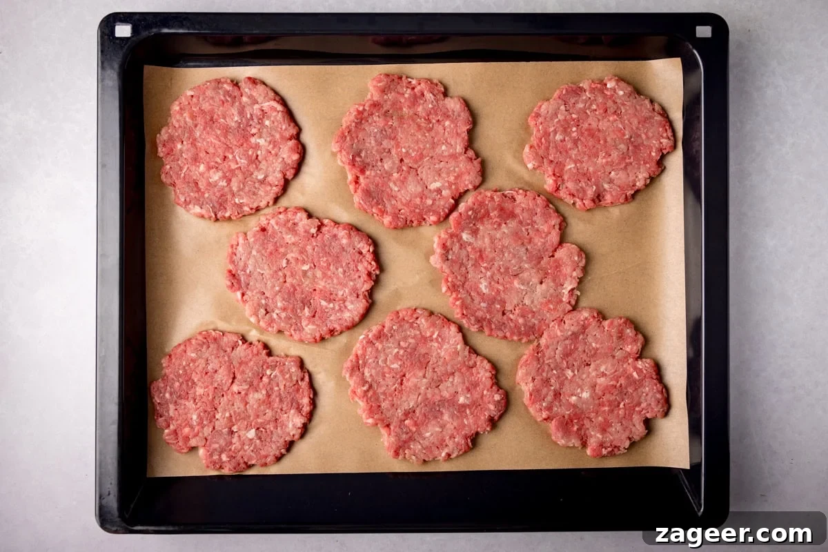 Meal Prep Powerhouse: Homemade High Protein Sausage and Egg McMuffin 5 A wide, overhead prep shot of Sausage and Egg McMuffin. The image shows 8 raw patties laid out on some light brown parchment paper