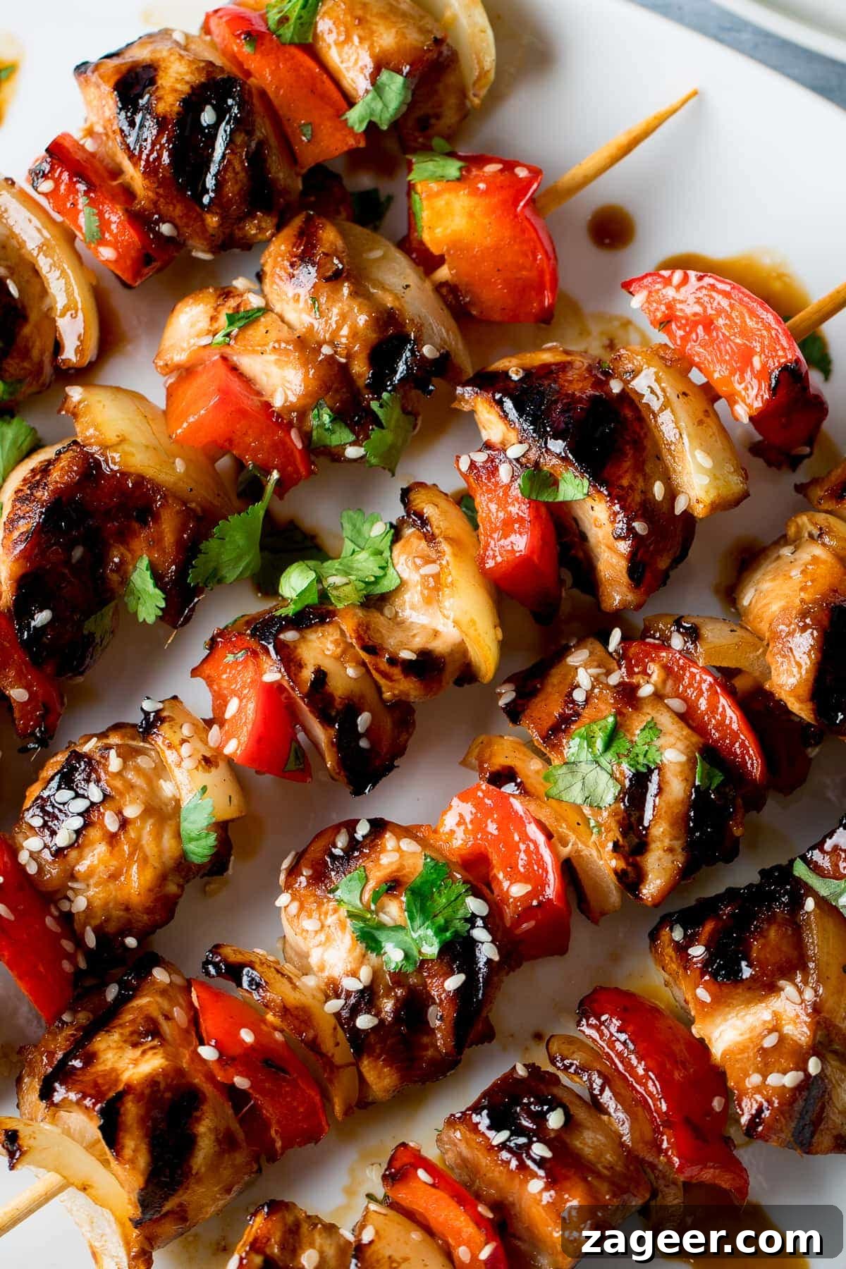 Sticky Honey Garlic Chicken Skewers 6 A close-up shot of several honey garlic chicken skewers, richly glazed and sprinkled with sesame seeds, presented beautifully
