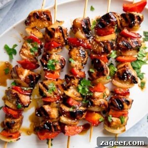 Sticky Honey Garlic Chicken Skewers 7 honey garlic chicken skewers on a white plate