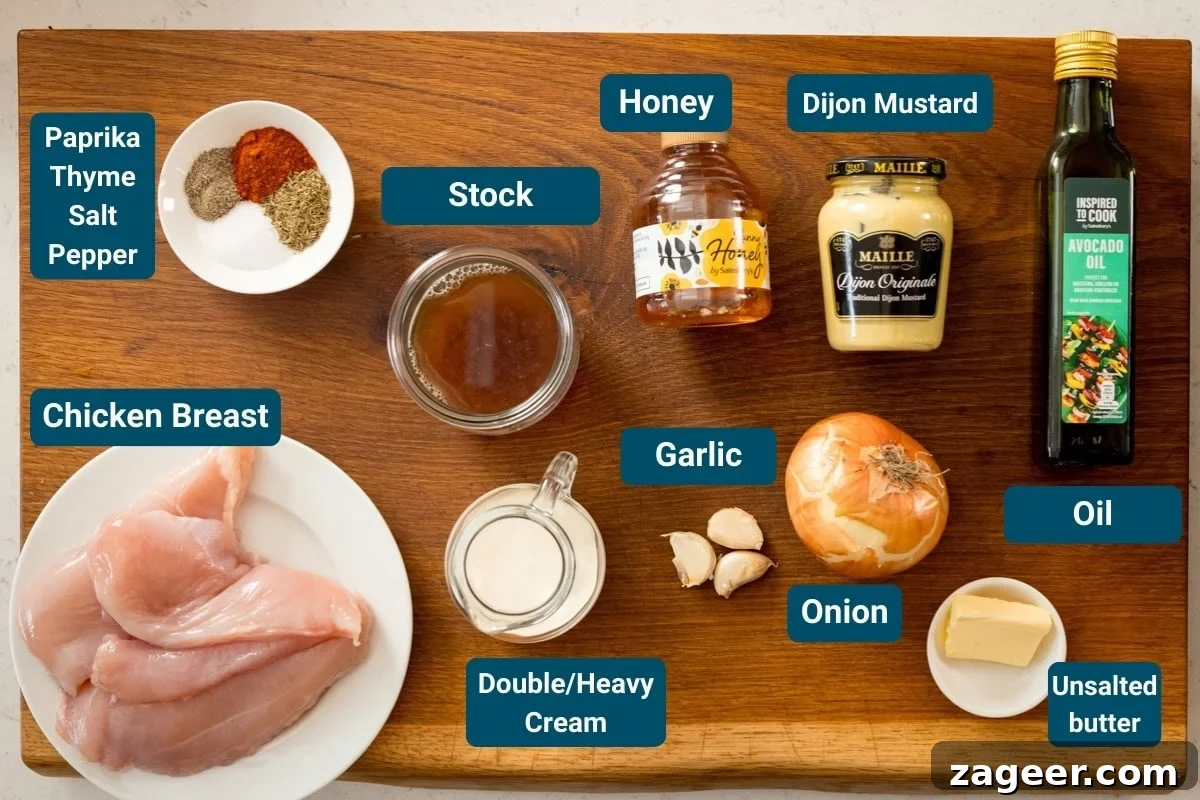 Golden Glazed Honey Mustard Chicken 4 Ingredients for honey mustard chicken on a wooden board, including; raw chicken breast, onion, garlic, double cream, stock, unsalted butter, oil, honey, Dijon mustard, and a plate of spices labeled paprika, thyme, salt and pepper.