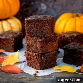 A generous slice of moist Pumpkin Gingerbread Cake, beautifully adorned with a glistening, sticky whisky glaze. This autumnal bake, rich in color and texture, suggests warmth and spicy comfort, perfect for festive gatherings.