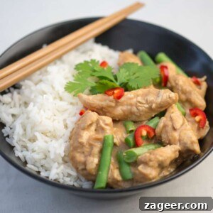 20-Minute Creamy Peanut Chicken 3 Old photo of a black bowl filled with rice and peanut butter chicken curry, green beans, chillies, and coriander on top. The photo quality is noticeably dated.