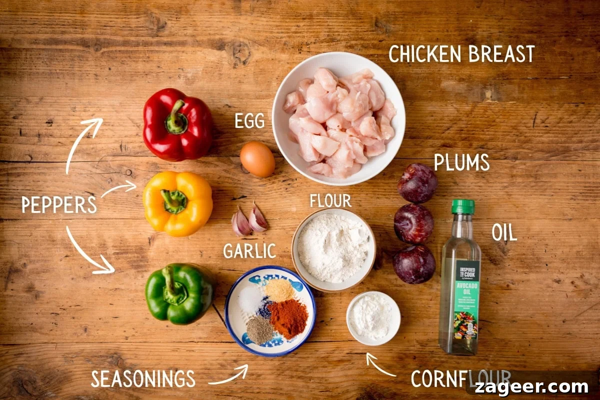 Imperial Plum Chicken Stir-Fry 3 Ingredients on a wooden table for making Crispy Chicken plum stir fry, including red, yellow, and green peppers, plums, chicken pieces, an egg, flour, garlic, spices, cornflour, and oil. Each ingredient is labelled.