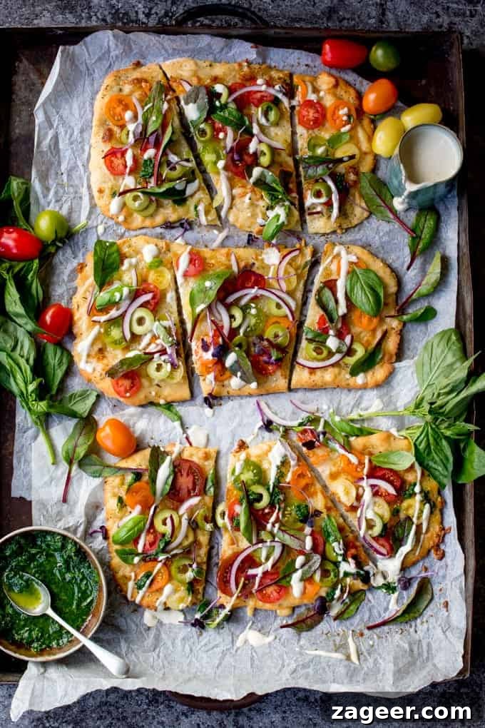Summer Tomato Pizza with Basil Garlic Butter (Vegetarian) 2 Vegetarian Summer Tomato Pizza with Basil Garlic Butter and creamy cashew drizzle on a wooden board with fresh basil leaves. This easy recipe features a homemade no-knead, no-prove flatbread base and is perfect for quick weeknight meals.