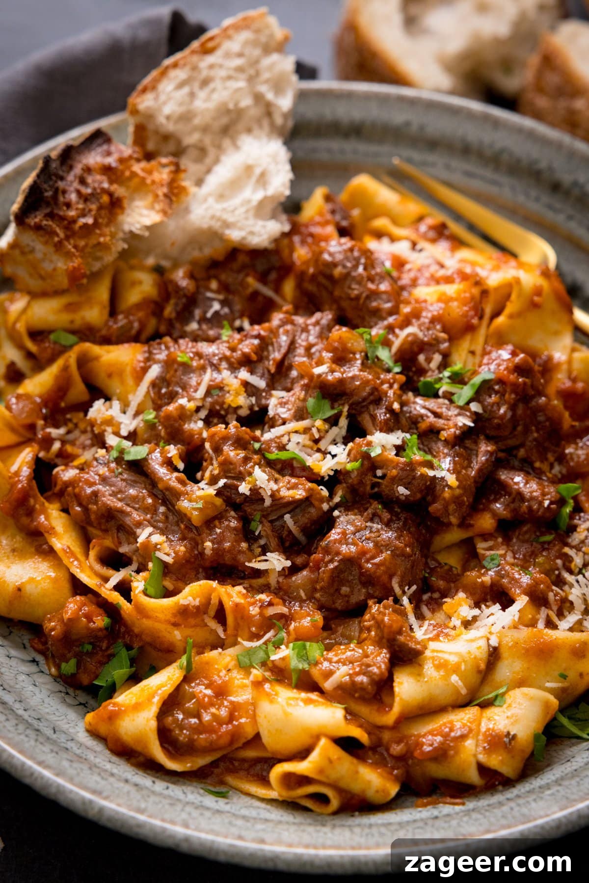 Beef Ragu with Pappardelle: A Hearty Slow-Cooked Meal Beef ragu with pappardelle in a bowl with a chunk of bread, highlighting the rich sauce and tender beef.