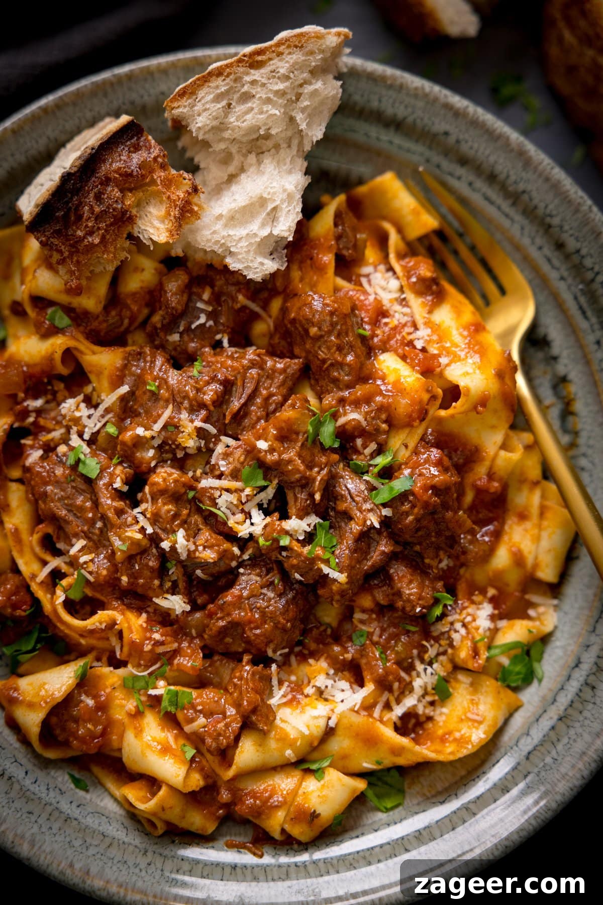 Classic Beef Ragu with Pappardelle Overhead image of beef ragu and pasta in a bowl, garnished with cheese and parsley.