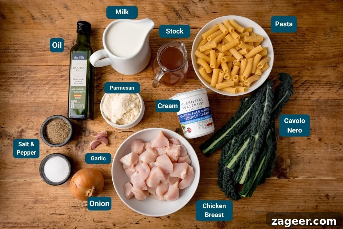 One-Pot Creamy Chicken Rigatoni Alfredo 4 Ingredients for an alfredo rigatoni pasta dish laid out on a wooden table, including chicken breast, pasta, cavolo nero, onion, garlic, salt & pepper, oil, milk, stock, cream, and parmesan cheese.