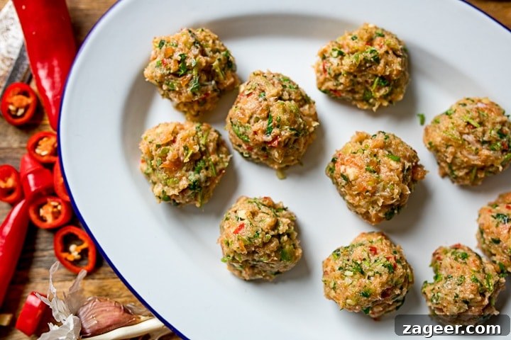 Golden Thai Fish Fritters and Vibrant Vegetable Ribbons 7 Raw Thai fishcake balls on a white plate