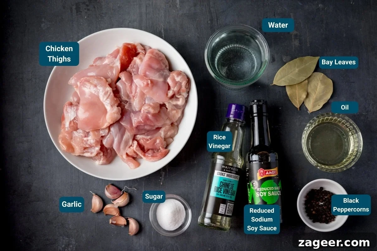 Authentic Filipino Chicken Adobo 4 Ingredients for Chicken Adobo on a dark background - Including: garlic, sugar, rice vinegar, reduced salt soy sauce, water, bay leaves, oil, and black peppercorns, ready to be prepared.