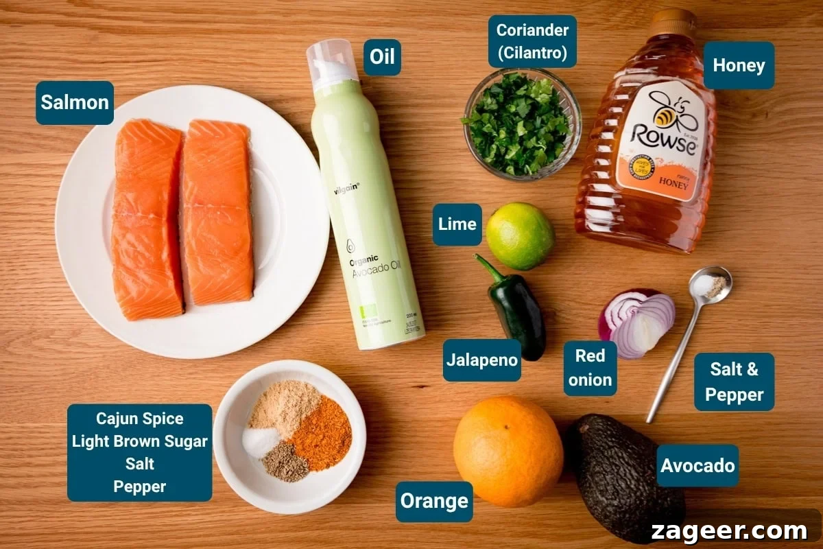 Crispy Air-Fried Salmon Bowl with Zesty Avocado-Orange Salsa 4 Ingredients for a salmon bowl recipe with orange-avocado salsa laid out on a rustic wooden surface. Visible are raw salmon fillets, a bottle of avocado oil, a jar of honey, a bunch of fresh coriander, whole limes, a jalapeño pepper, a red onion, and ingredients for the salsa including a diced avocado and orange segments, alongside a selection of spices. Each ingredient is clearly labelled.