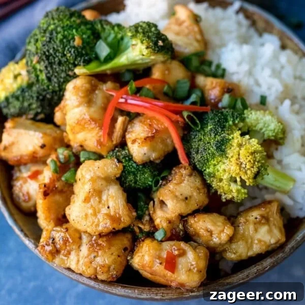 Crispy Chili Beef Noodles Recipe for Flavorful Weeknight Dinner 11 Square image of Asian crispy chicken with broccoli and rice in a stoneware bowl.